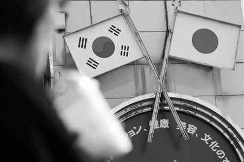 8月2日，在日本首都东京的新大久保，行人从标有日本和韩国国旗的广告牌前走过。新华社发